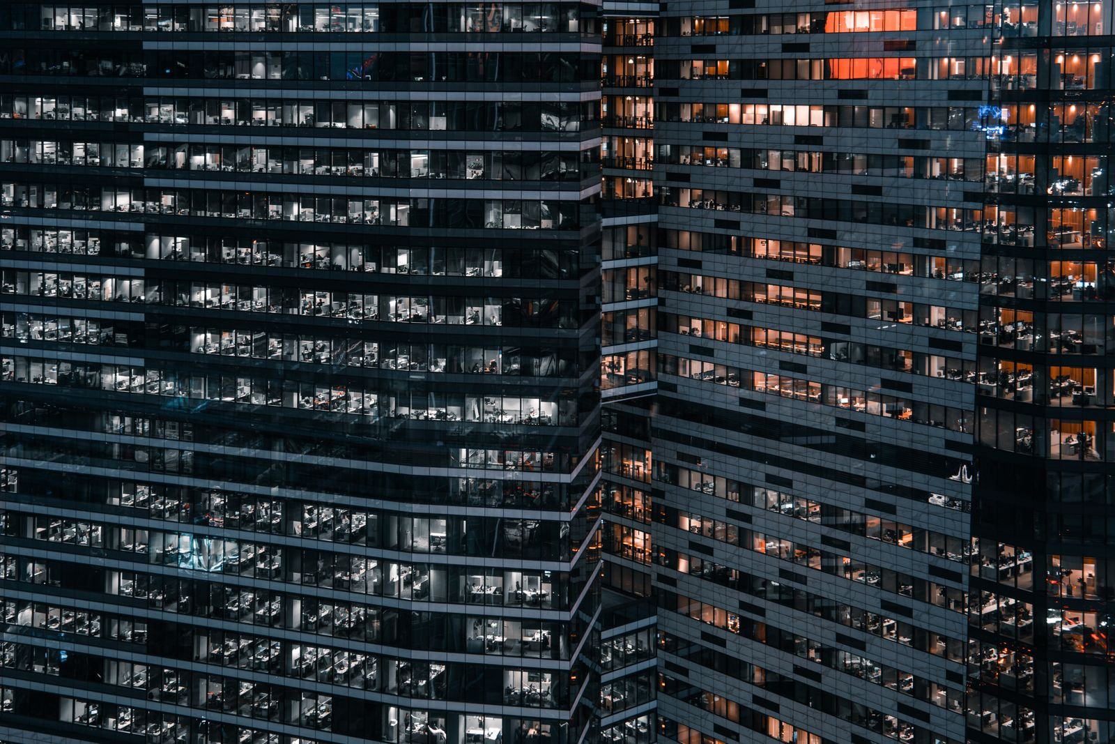 Fachada de torres residenciales modernas con ventanales iluminados de noche