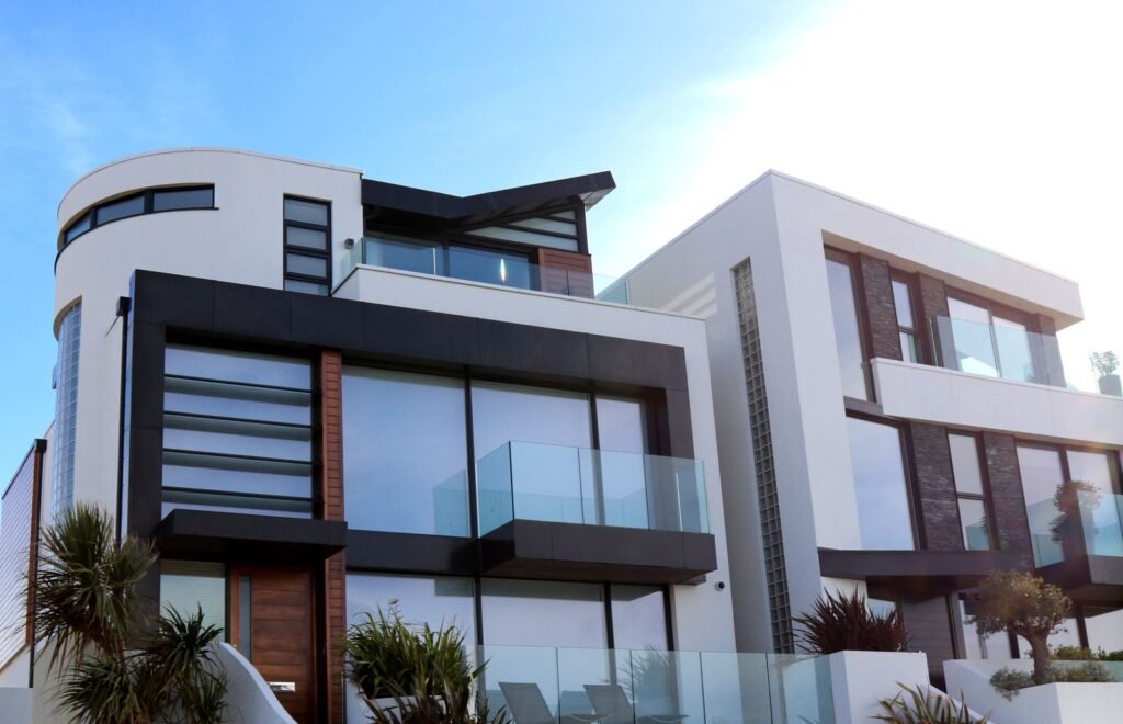 Fachada de arquitectura residencial moderna con líneas curvas, ventanales y balcones de vidrio en un barrio privado