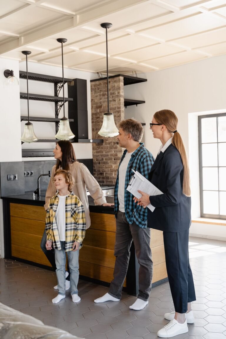 Asesora inmobiliaria mostrando una cocina moderna a una familia interesada en comprar