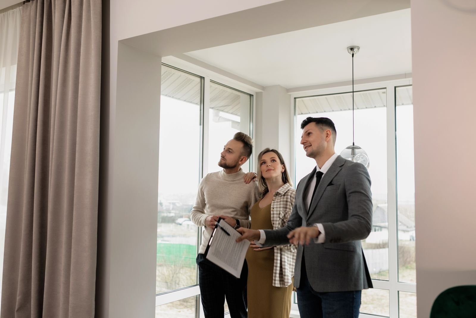 Agente inmobiliario mostrando un apartamento luminoso a una pareja interesada