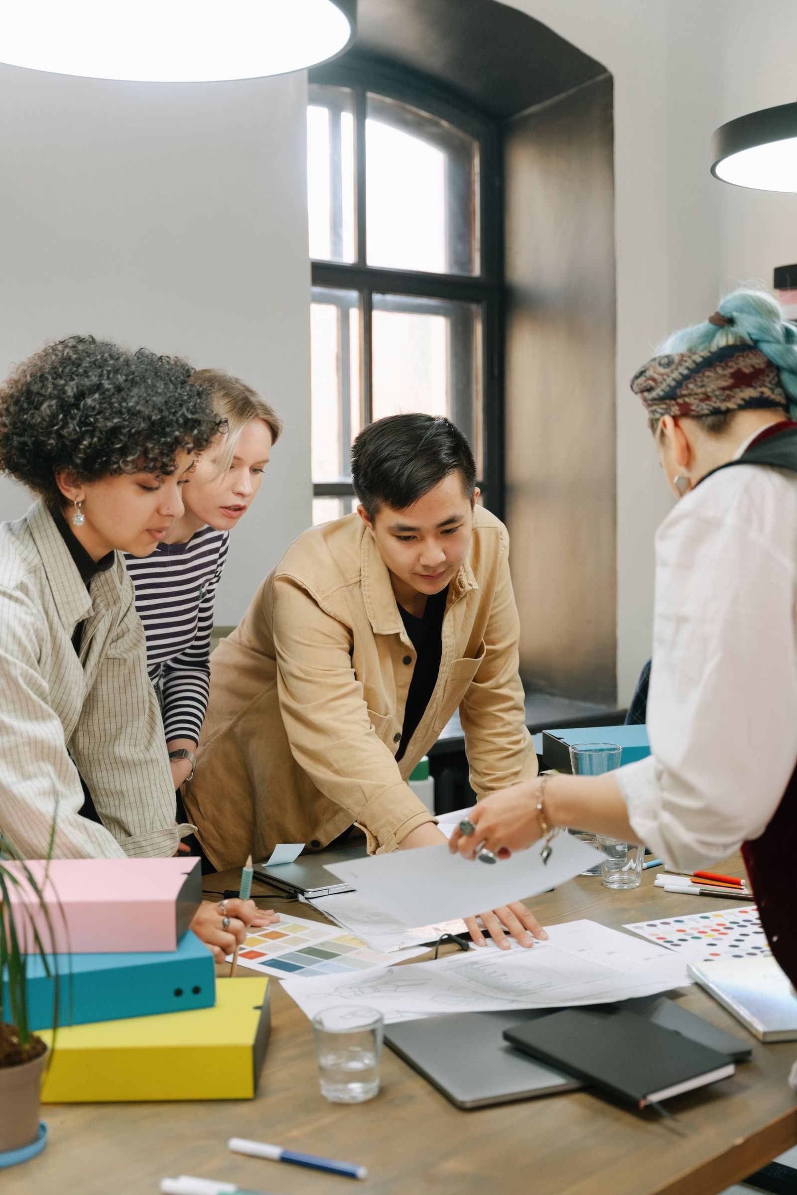 Grupo de personas revisando juntas planos y documentos sobre una mesa de trabajo
